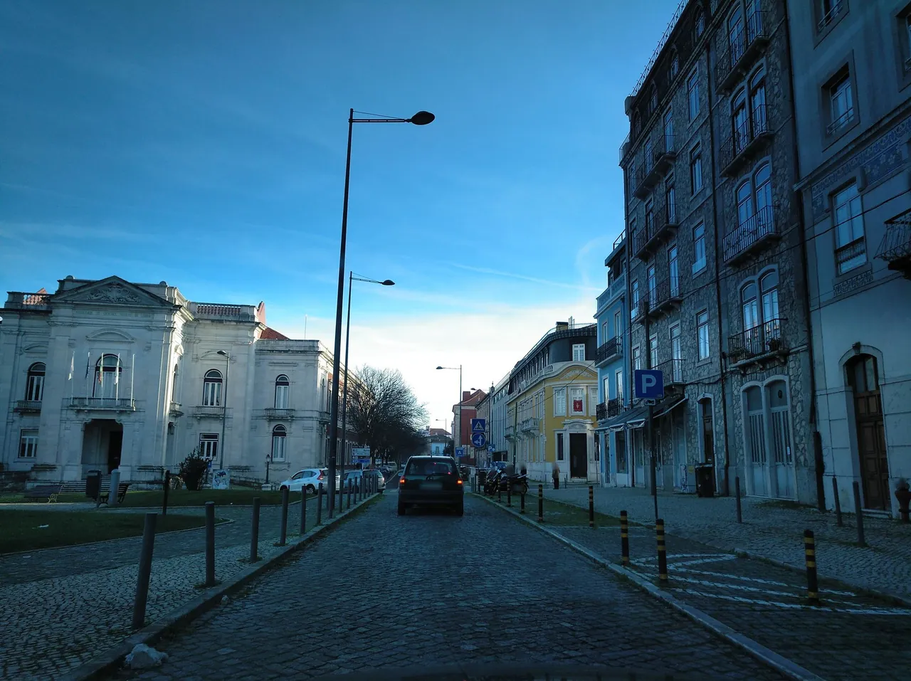 A cobbled street beside decorative facades and iron balconies in Lisbon.